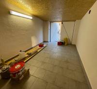 Szerszámokkal és világítással ellátott garázsok, fa dekorú padló, nyitott ajtó a nappali fényhez.