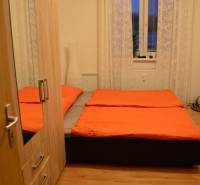 Hálószoba egy kétszobás lakásban ággyal, szekrénnyel és fa dekorációjú padlóval.