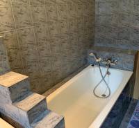 Fürdőszoba öntöttvas káddal és lépcsőkkel, tipikus kétszobás lakásban.