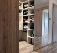 Beépített szekrény tolóajtókkal és fa dekorációjú padló családi házban.