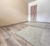 Családi ház helyisége fa dekorációjú padlóval és világos falakkal.