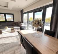 Családi ház nappalija fa dekorációjú padlóval és kényelmes ülőgarnitúrával.