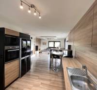 Konyha családi házban fa dekor padlóval és praktikus ülőhellyel.