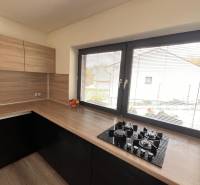 Konyha fa dekorációval és pulttal egy családi házban, ablakkal és gázfőzővel.