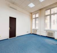 Irodák kék szőnyeggel, fehér falakkal és nagy ablakokkal.