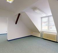 Iroda ablakkal és radiátorral, fa dekor padlóval, fali aljzatokkal.