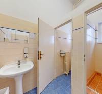 Irodák mosdóval, csempével és zuhanyzóval, kerámia dekorációjú padlóval.