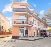 Az épület a Dunaszerdahelyen, a Kukučín utcában, világos narancssárga homlokzattal és üzletekkel.