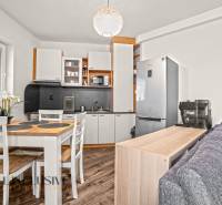 Konyha egy kétszobás lakásban fa dekor padlóval és étkezőasztallal.