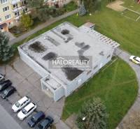 Rimaszombatban az üzlethelyiségeket panelházak és parkolóhelyek veszik körül.