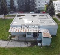 Kilátás a rimaszombati üzlethelyiségekre a szomszédos parkkal és beton tetővel.