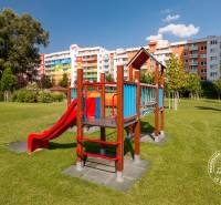 Játszótér a Bosákova utcán, színes lakóházakkal és zölddel körülvéve.