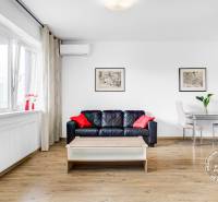 Nappali fa dekorációjú padlóval, kanapéval és étkezőasztallal egy kétszobás lakásban.