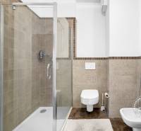 Fürdőszoba tágas zuhanyzóval és mosdóval egy kétszobás lakásban.