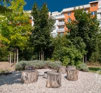 A Bosákova utcában, színes lakóház, kert fa ülőgarnitúrával a kétszobás lakás előtt.