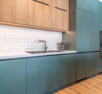 Konyha türkiz szekrényekkel, fa dekorációval és fehér csempékkel, 3 szobás lakás.