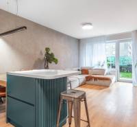 Nappali egy háromszobás lakásban kényelmes kanapéval és fa dekorációjú padlóval.