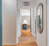 3 szobás lakás belső tere fa mintázatú padlóval és kerek tükörrel.