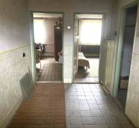 Családi ház belső tere folyosóval és szobák bejáratával, fa dekoros padlóval.