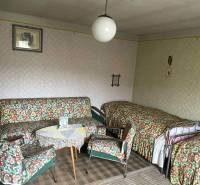 Szoba egy családi házban retro bútorokkal, mintás kárpitokkal és szőnyeggel.