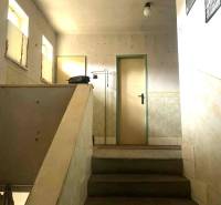 Egyszerű lépcső egy családi házban, minimalista belső térrel és világos falakkal.