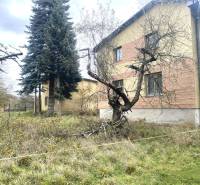 Családi ház Rykynčiceben, fákkal és füves kerttel körülvéve az őszi időszakban.