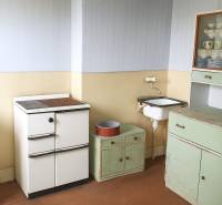 Családi ház konyhája retro bútorokkal és mosogatóval.