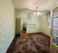 Szoba egy családi házban szőnyeggel, zöld falakkal és dekoratív világítással.