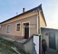 Családi ház Udvardon vakolt homlokzattal, külső lépcsőkkel és udvarral.