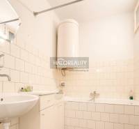 Fürdőszoba családi házban káddal, mosdóval és fa dekorációjú padlóval.