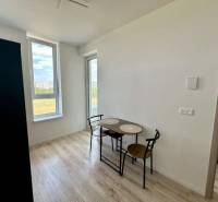 Étkező sarok egy kétszobás lakásban fa mintázatú padlóval és nagy ablakokkal.