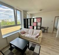 Nappali egy kétszobás lakásban fa dekor padlóval, kanapéval és asztallal.