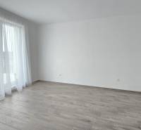 Világos szoba egy családi házban, fa dekorációjú padlóval és függönyökkel.