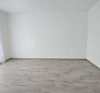 Tágas szoba fa dekorációjú padlóval és nagy ablakokkal egy családi házban.