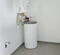 Családi ház kazánnal és vízmelegítő berendezéssel. Szürke padlóburkolat.