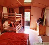 Négyágyas faház belső tere világos kilátással a teraszra.