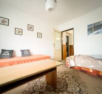 Nappali egy családi házban szőnyeggel és rajzokkal a falon.