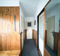 Családi ház előszobája fa burkolattal és tükörrel a falon.