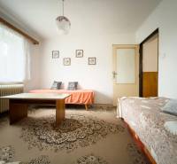 Nappali családi házban két kanapéval és egy asztallal a szőnyegen.