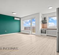 Nappali konyhasarokkal egy kétszobás lakásban, fa dekor padlóval.