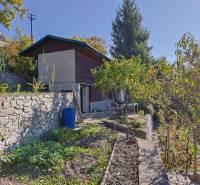 Kertek Pozsonyban - Dévényben a Spätna úton, kőfal, fák és növényzet.