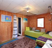 Fa falburkolat, kanapék párnákkal és szőnyeggel a kerti ház belsejében.