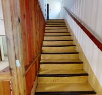 Fa lépcső fa korláttal és fallal a kunyhó belsejében.