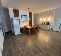 Étkező sarok egy kétszobás lakásban asztallal és székekkel, fa dekorációjú padlóval.