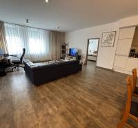 2 szobás lakás nappalija sötét kanapéval és dolgozósarokkal.