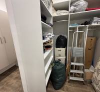 Skladolási tér a kétszobás lakásban polcokkal, lépcsőkkel és dobozokkal.