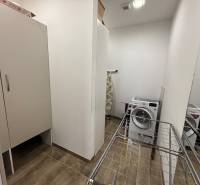 Mosógéppel, szárítóval és szekrénnyel ellátott fülke egy kétszobás lakásban; fa dekorációjú padló.