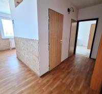 3 szobás lakás belső tere fa dekorációjú padlóval és kőburkolattal.