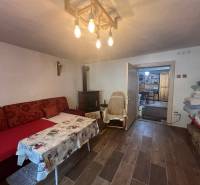 Kényelmes szoba a házban, hangulatos ülőhellyel, kandallóval és fából készült mennyezettel.