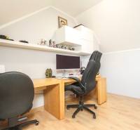 Négy szobás lakás dolgozószobája számítógéppel, irodai székkel és fa dekor padlóval.